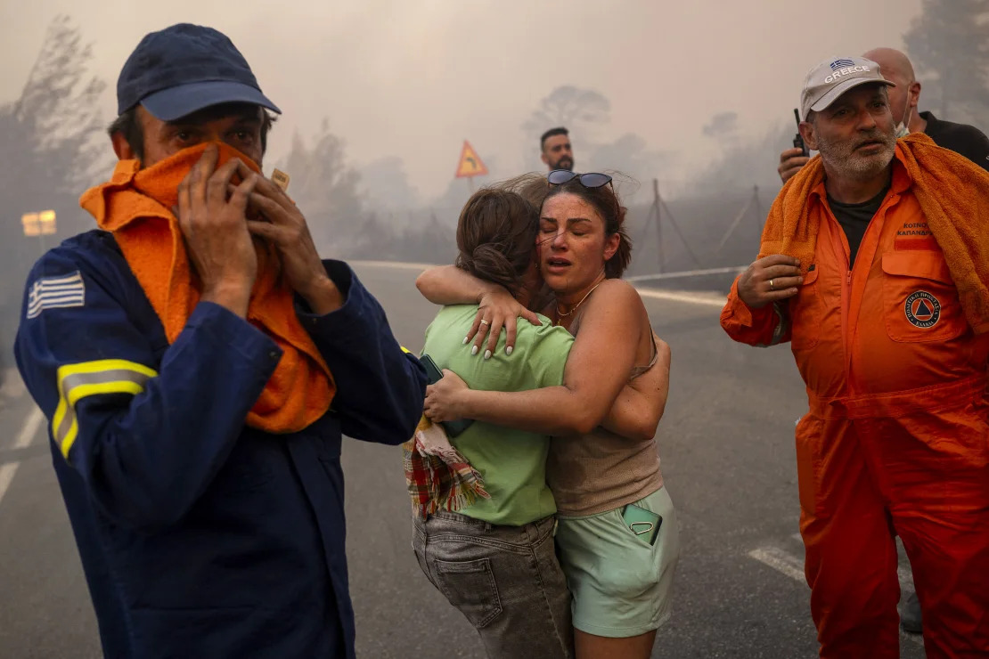 Emergency service personnel work to rescue people during wildfires in Varnavas, north of Athens
